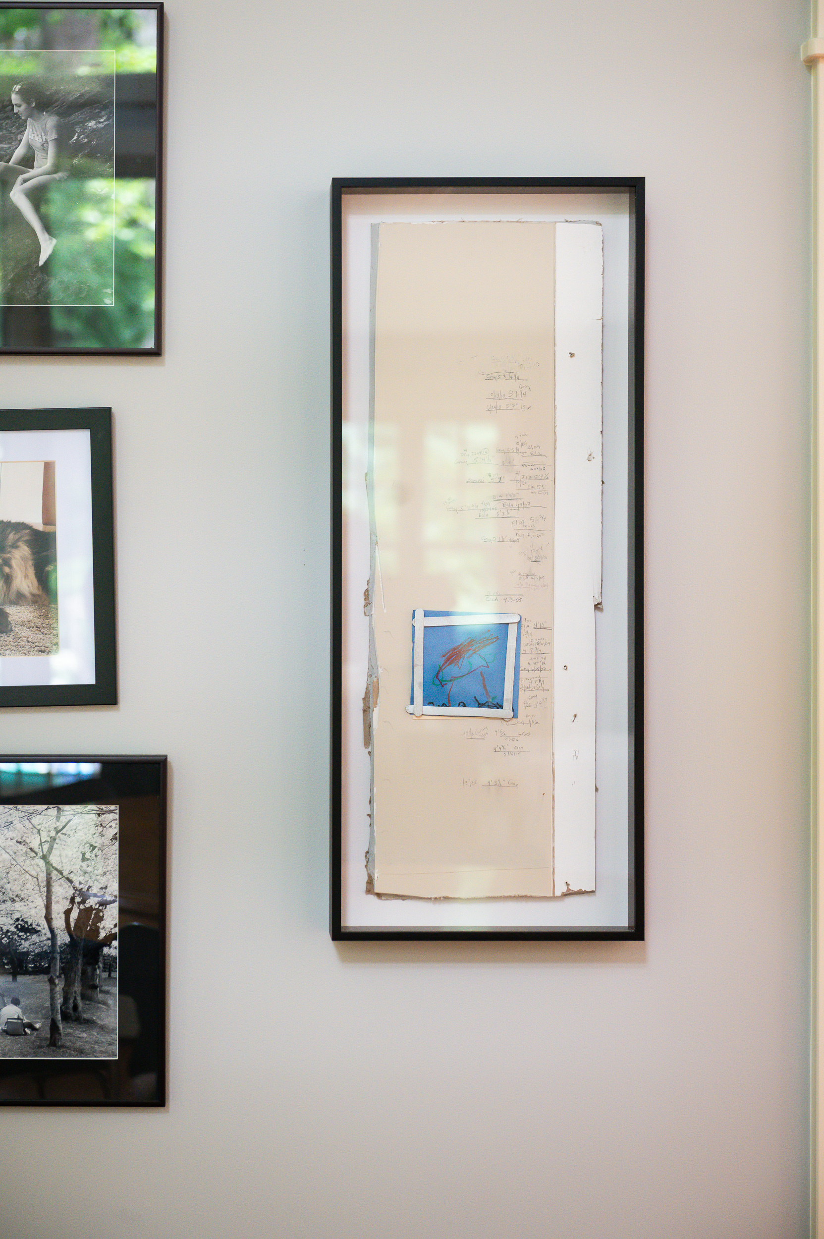 Framed family growth chart displayed near the kitchen